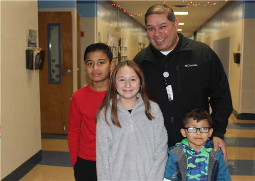 police chief, Charlie Ramirez with three students